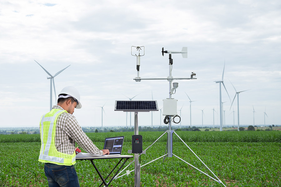 Engineer using tablet computer collect data with meteorological instrument